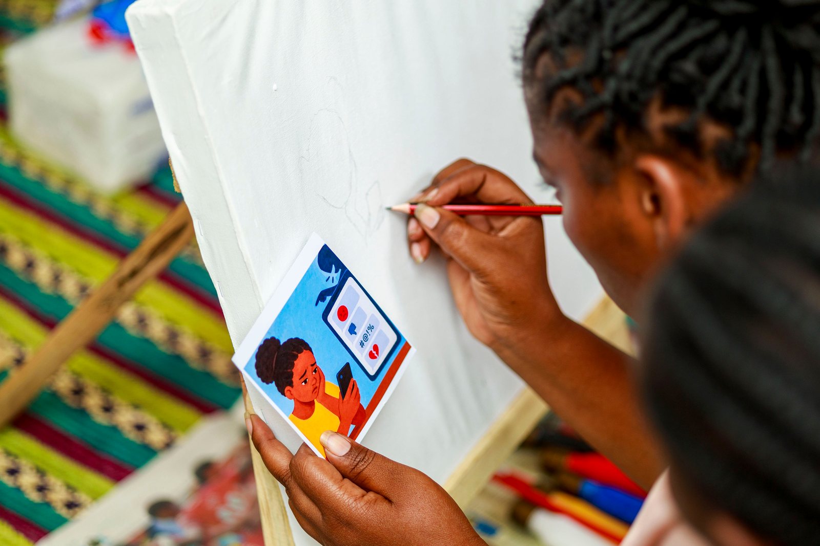 A young woman paints on canvas during a Safe Corner creative skills session