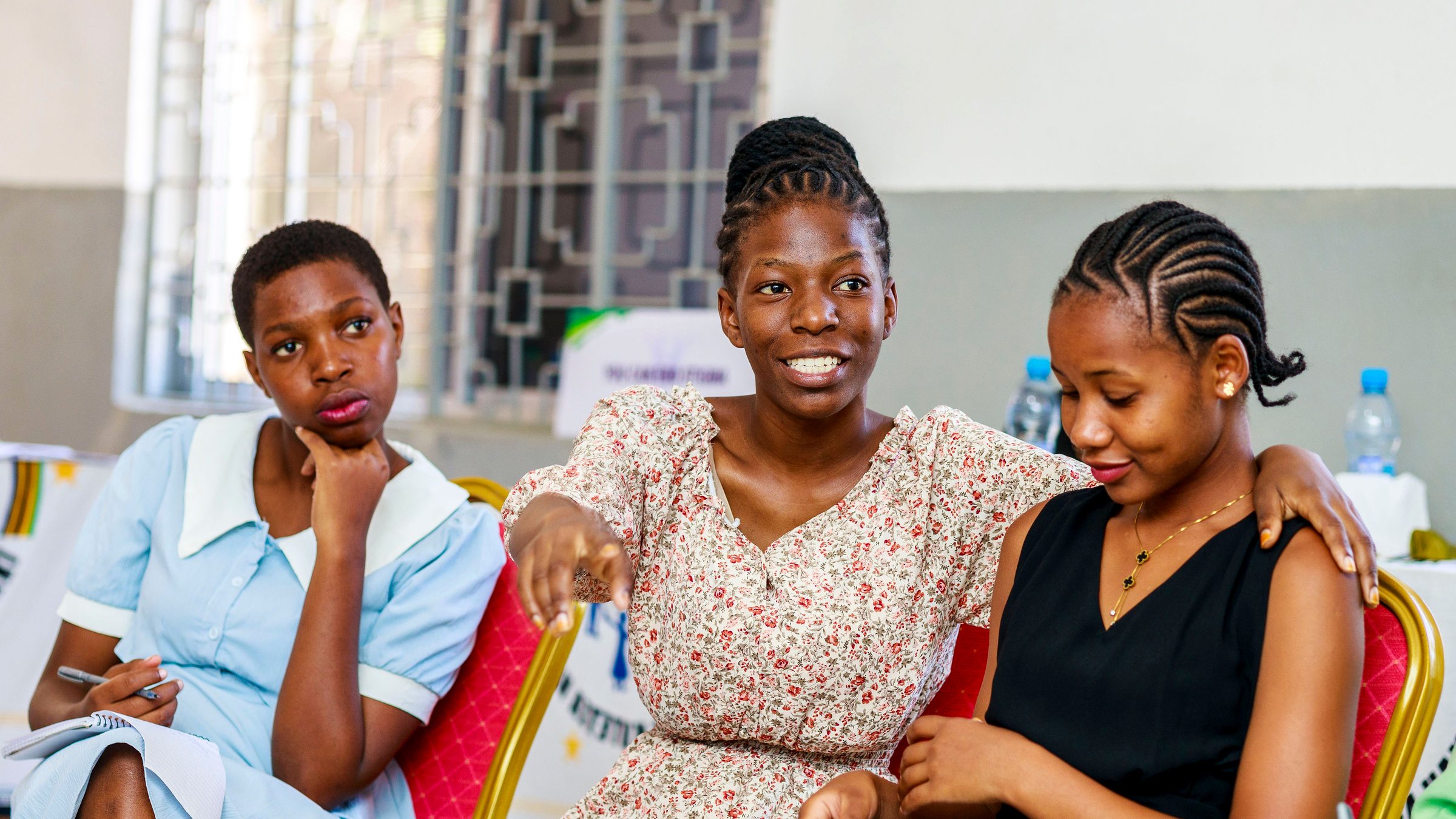 Three girls laughing together during a Safe Corner Project session